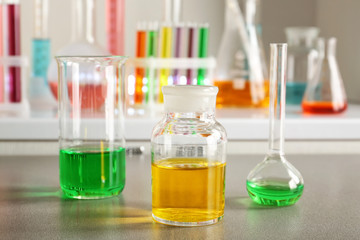 Chemical glassware with colorful samples on table in laboratory