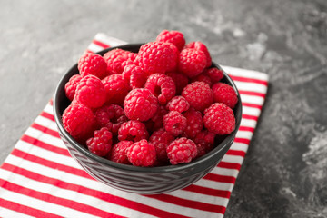 Bowl with fresh ripe raspberries on table