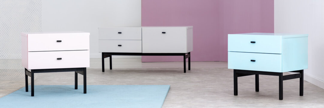 Panorama of pastel cabinets in minimal colorful living room interior with rug. Real photo