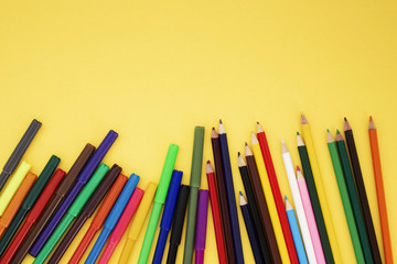 Back to school flat lay. Colour pencils on yellow background. Copy space