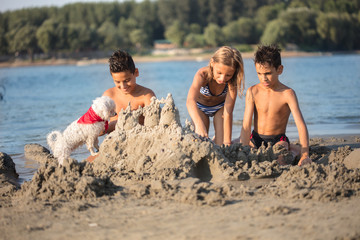 children making sand castle at tropical beach