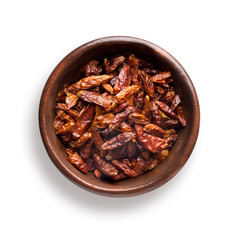 chili peppers dried in a wooden bowl, isolated on white
