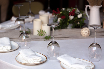 Beautifully decorated catering on bright tablecloths. Serving with glasses, plates, cutlery, flowers and a fan
