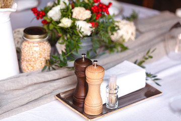 Beautifully decorated catering on bright tablecloths. Serving with glasses, plates, cutlery, flowers and a fan