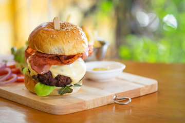 Hamburgers and French fries on the wooden tray.