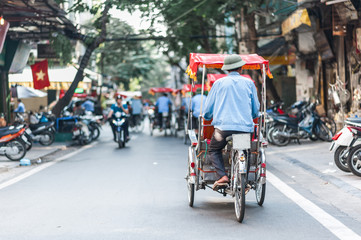 Traditional cyclo ride down the streets of Hanoi, Vietnam. The cyclo is a three-wheel bicycle taxi...