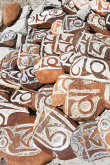 Buddhist prayer stones with Tibetan inscriptions and ritual drawings on the store of lake Manasarovar
