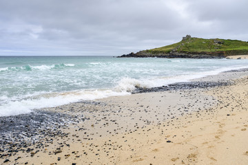 Rough sea crashing on the shore at Porthmeor beach, St Ives, Cornwall.