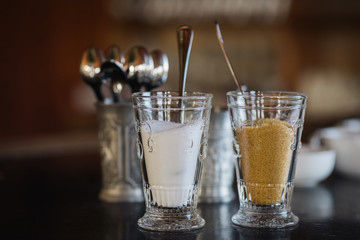 sweet white sugar and brown sugar in two glasses with spoon, decorative