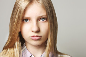 Close up portrait of beautiful teenager girl with sad depressed facial expression. Pretty young woman with long blonde hair looking stressed and worried. isolated background, copy space.