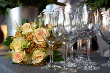 Beautiful flowers on the table with empty wine glasses