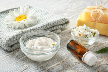 Composition with natural cosmetics and chamomile flowers on table