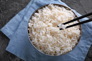 Eating of tasty boiled rice with chopsticks, closeup