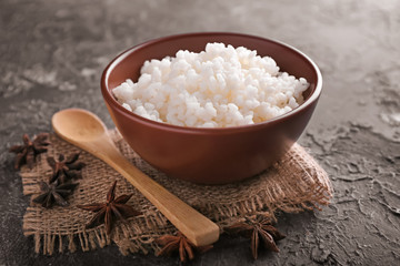 Obraz na płótnie Canvas Bowl with boiled white rice on grey textured background