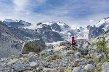 Senior woman, riding her e-mountain bike on the trail to the Morteratsch glacier near Pontresina ,...