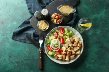 Plate with tasty Caesar salad on table