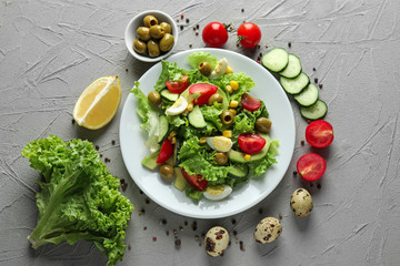 Composition with tasty vegetable salad and ingredients on table