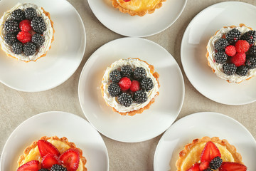 Plates with tasty tartlets on table, top view