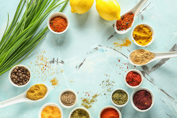 Frame made of different spices on color background
