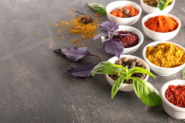 Composition with different spices and herbs on grey background
