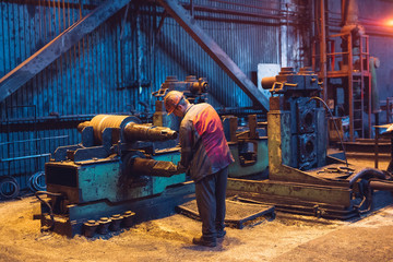 Heavy Industry Worker Working Hard on Machine. Rough Industrial Environment.