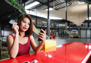 Asian woman enjoy with her smartphone for social network and shopping online in relax time,Women enjoy with hot sale day,Beatifule Asian woman shopping online with her credit card