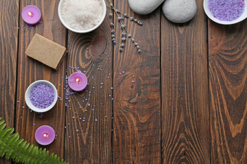 Fototapeta na wymiar Composition with spa cosmetics, candles and lavender on wooden table