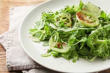 Plate with healthy vegetable salad on table