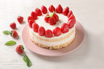 Delicious cake with strawberries on wooden table