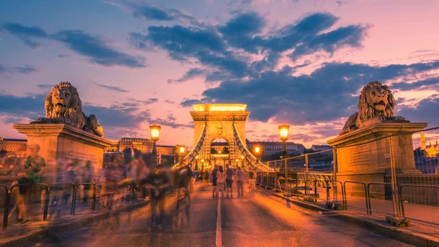 Szechenyi Chain Bridge in Budapest with a blurred crowd of people at sunset. Time lapse. Zoom out effect