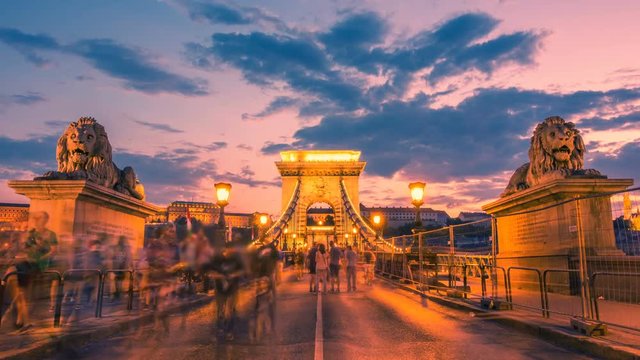 Szechenyi Chain Bridge in Budapest with a blurred crowd of people at sunset. Time lapse. Zoom effect