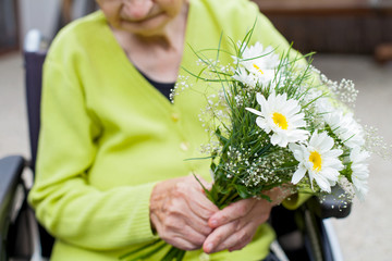 Elderly woman receiving flowers