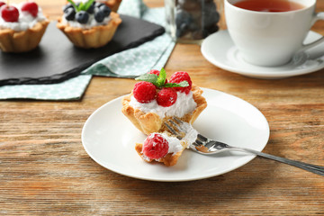 Tasty tartlet with raspberries on plate