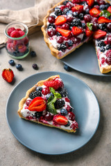 Plate with piece of delicious berry pie on table