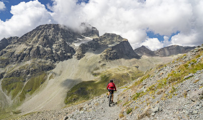 Fototapeta premium active senior woman, riding her e-mountainbike on the famous Suvretta Loop trail, high above Saint Moritz, Engadin, Switzerland