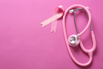 Pink ribbon and stethoscope on color background. Breast cancer awareness concept