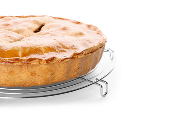 Cooling rack with delicious apple pie on white background