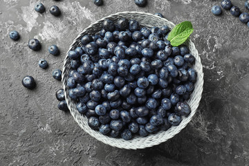 Bowl with ripe blueberries on grunge table