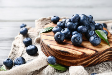 Board with ripe blueberries on table, closeup