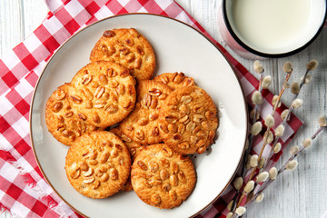 Plate with tasty cookies and cup of milk on wooden table