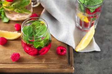 Glass of fresh raspberry mojito on board