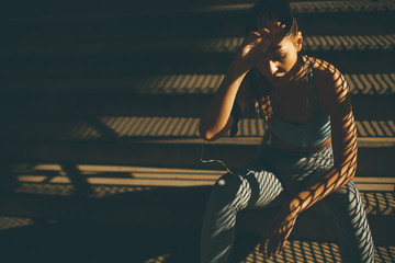 Young female runner resting on the stairs