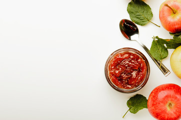 Apple butter, ripe apples and a spoon for jam on a white background. Autumn meal, harvest time. copy space, top view.