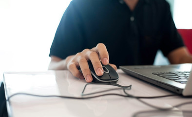 Black shirt men is clicking mouse and using computer,selective focus