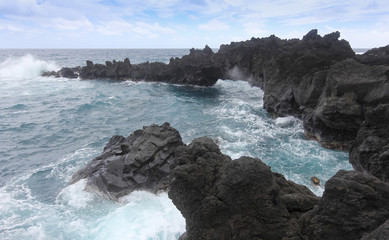 Fototapeta na wymiar A View of Churning Waves and Spray at the Sea Arches, Waianapanapa State Park