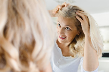 Happy woman cheking her hair