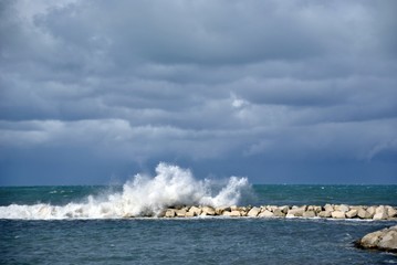 windy day at sea with big waves against rocks