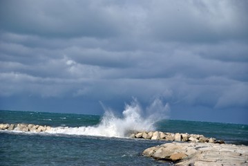 windy day at sea with big waves against rocks