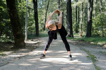 Senior woman strething in park