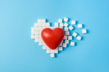 big red heart on broken heart made of sugar cubes on a blue background